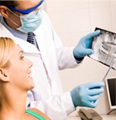 Dentist explaining to a patient that often, a tooth that has become infected because of a neglected cavity or trauma can be saved with modern root canal therapy